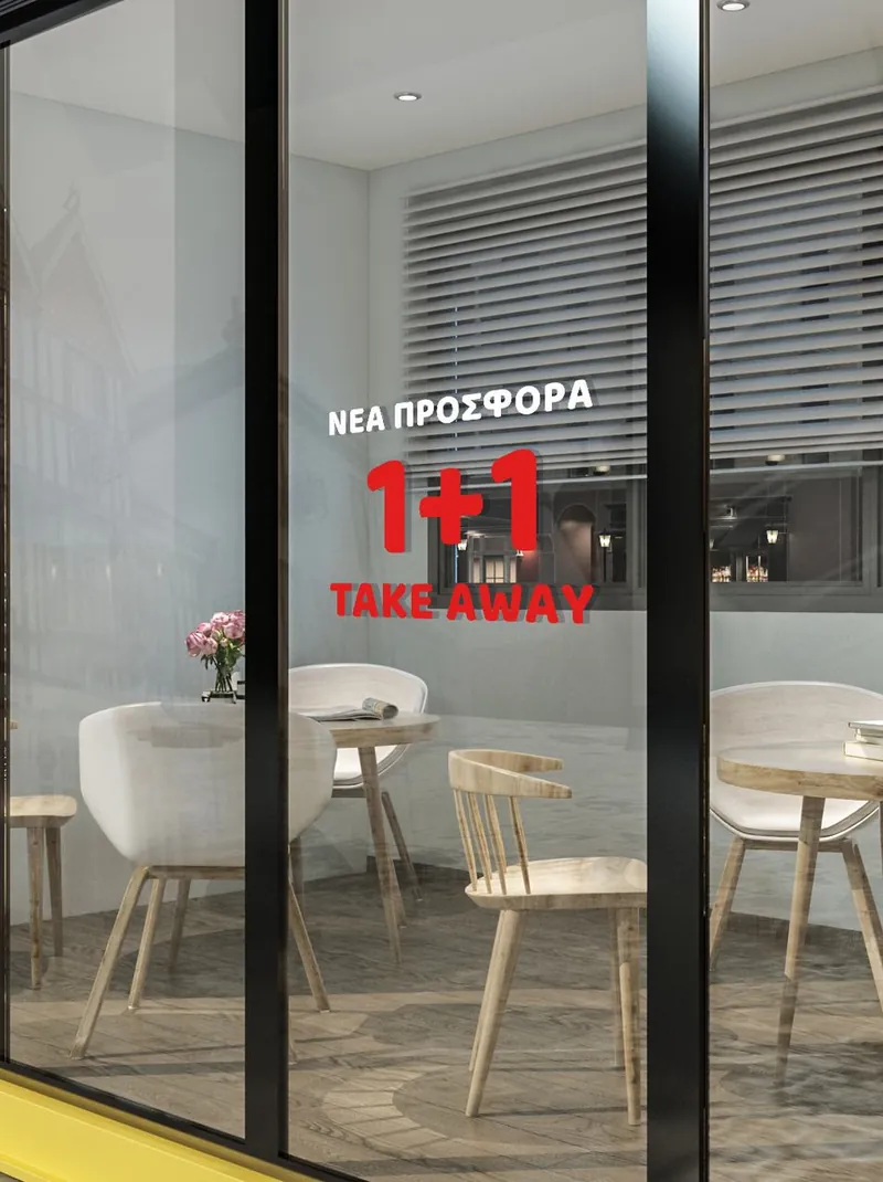 Βιτρίνα καφέ με κόκκινα αυτοκόλλητα «Νέα προσφορά 1+1 take away»